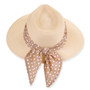 Front three-quarter studio view of Sun N Sand tapered safari hat featuring cream woven texture, polka dot scarf and metal plaque