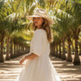 Lifestyle profile portrait of the Sun N Sand HH3622 A Women’s Safari Hat in a natural woven straw, featuring a matching woven hatband with a side metallic brand plate and a wide, structured flat brim with a pinched crown for an adjustable fit and UPF 50+