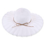 White woven floppy hat with scalloped brim, concentric stitching, tan decorative string, small metallic side emblem, shown in clear front angled view.