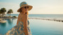 Lifestyle profile portrait of the Sun N Sand HH3646 Women’s Bucket Hat in a dual-toned paperbraid weave with a light blue crown and natural tan brim, featuring a gold-toned palm tree motif on the crown and a thin matching cord hatband for an adjustable fit and UPF 50+ sun protection.