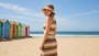 Lifestyle portrait of the Sun N Sand HH3647 Women’s Bucket Hat in a dark natural tan paperbraid weave, featuring a matching braided hatband with a side metallic brand plate and a structured down-sloping brim for an adjustable fit and UPF 50+ sun protection.