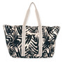 rear view of a rectangular navy crossbody bag featuring a white tropical leaf print, front zipper pocket, and silver logo hardware.