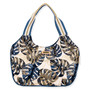 front view of a slouchy canvas tote bag featuring a navy and gold monstera leaf print with striped shoulder straps.
