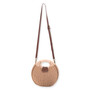 Front view of a brown circular woven bag featuring cream-wrapped top handles, a dark brown adjustable strap, and gold-tone hardware.