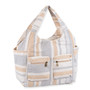 Three-quarter view of neutral striped canvas hobo tote, two front zippered pockets, deep side slip pockets, and integrated handles.