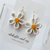 Hollow floral hoops available in either daisies or black eyed susans!
Earrings are finished with 20mm 18k gold plated hoops.