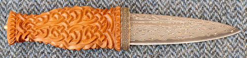 Traditional Scottish Sgian Dubh with Highland Oak handle carved with Celtic Knotwork, Brass lower ferrule band engraved with Celtic Knotwork, Brass Top Stud and patterned Stainless steel blade (serial number SGGK12)