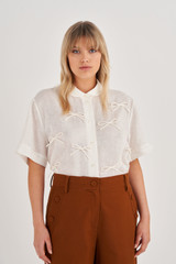 Profile view of model wearing the Oroton Bow Detail Shirt in Antique White and 100% Linen for Women