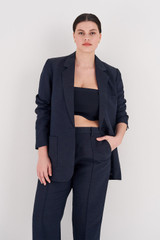 Profile view of model wearing the Oroton Single Breasted Blazer in North Sea and 58% Viscose, 42% Linen for Women