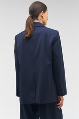 Profile view of model wearing the Oroton Single Breasted Blazer in North Sea and 98%  wool, 2% elastane for Women . IP:5
