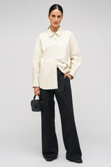 Profile view of model wearing the Oroton Leather Overshirt in Paper White and 100% Leather for Women