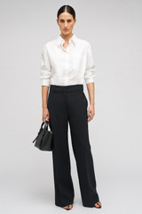Profile view of model wearing the Oroton Poplin Long Sleeve Shirt in White and 100% cotton for Women