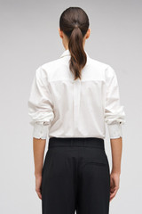 Profile view of model wearing the Oroton Poplin Long Sleeve Shirt in White and 100% cotton for Women