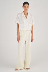 Profile view of model wearing the Oroton Cropped Scallop Camp Shirt in White and 100% Linen for Women