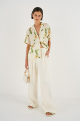 Profile view of model wearing the Oroton High Waist Pleat Pant in Soft Cream and 100% Linen for Women
