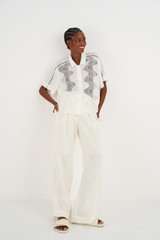 Profile view of model wearing the Oroton High Waist Pleat Pant in Soft Cream and 100% Linen for Women