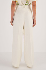 Profile view of model wearing the Oroton High Waist Pleat Pant in Soft Cream and 100% Linen for Women