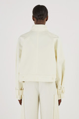 Profile view of model wearing the Oroton Crop Trench in Cream and 77% Cotton 23% Linen for Women
