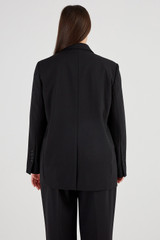 Profile view of model wearing the Oroton Double Breasted Blazer in Black and 53% polyester, 42% virgin wool, 5% elastane for Women