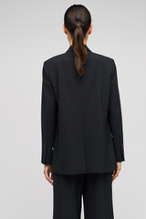 Profile view of model wearing the Oroton Double Breasted Blazer in Black and 53% polyester, 42% virgin wool, 5% elastane for Women .