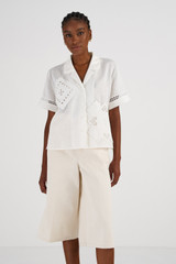 Profile view of model wearing the Oroton Lace Detail Camp Shirt in Antique White and 100% Linen for Women