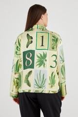 Profile view of model wearing the Oroton Fern Garden Long Sleeve Shirt in Cream and 100% Silk for Women