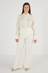 Profile view of model wearing the Oroton Flat Fronted Pant in Cream and 53% Polyester 43% Wool 4% Elastane for Women