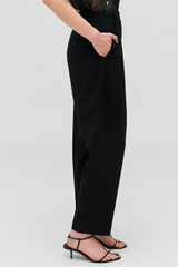Profile view of model wearing the Oroton Pleat Pant in Black and 53% Polyester 42% Wool 5% Elastane for Women . IP:4
