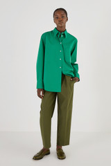Profile view of model wearing the Oroton Poplin Long Sleeve Shirt in Holly and 100% Cotton for Women