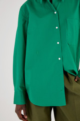Profile view of model wearing the Oroton Poplin Long Sleeve Shirt in Holly and 100% Cotton for Women