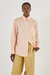 Profile view of model wearing the Oroton Poplin Long Sleeve Shirt in Iced Pink and 100% Cotton for Women