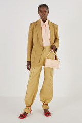 Profile view of model wearing the Oroton Poplin Long Sleeve Shirt in Iced Pink and 100% Cotton for Women
