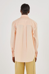 Profile view of model wearing the Oroton Poplin Long Sleeve Shirt in Iced Pink and 100% Cotton for Women