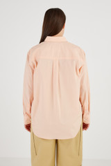 Profile view of model wearing the Oroton Poplin Long Sleeve Shirt in Iced Pink and 100% Cotton for Women