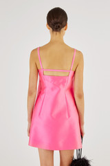 Profile view of model wearing the Oroton Satin Mini Bow Dress in Candy Pink and 85% Polyester, 15% Silk for Women