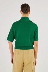 Profile view of model wearing the Oroton Mesh Stitch Polo in Kelly Green and 83% Viscose 17% Polyester for Women
