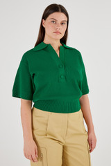 Profile view of model wearing the Oroton Mesh Stitch Polo in Kelly Green and 83% Viscose 17% Polyester for Women