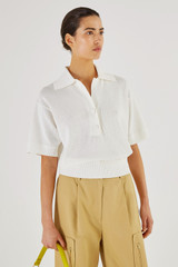 Profile view of model wearing the Oroton Mesh Stitch Polo in White and 83% Viscose 17% Polyester for Women
