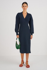 Profile view of model wearing the Oroton Long Sleeve Rib Knit Dress in North Sea and 83% Viscose 17 % Polyester for Women