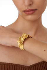 Profile view of model wearing the Oroton Amara Cuff in Worn Gold and Brass Base With 18CT Gold Plating for Women