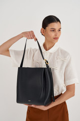 Profile view of model wearing the Oroton Ingrid Hobo in Black and Pebble Leather for Women