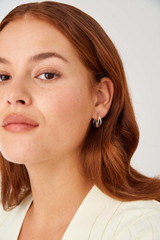 Profile view of model wearing the Oroton Nora Mini Hoops in Gold/Silver and Brass Base With Rhodium Plating for Women . IP:2
