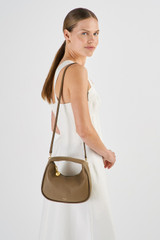 Profile view of model wearing the Oroton Clara Mini Bag in Willow and Pebble Leather for Women .
