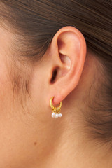 Profile view of model wearing the Oroton Como Hoops in Worn Gold/Pearl and Brass base metal with precious metal plating/pearl for Women