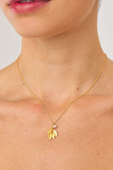 Profile view of model wearing the Oroton Sage Charm Necklace in Worn Gold and  for Women