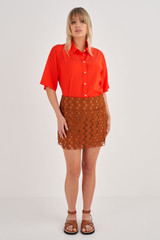 Profile view of model wearing the Oroton Short Lace Skirt in Tan and 100% Polyester for Women