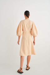 Profile view of model wearing the Oroton Sculptured Dress in Pale Mango and 100% Linen for Women