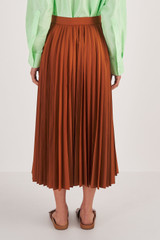 Profile view of model wearing the Oroton Pleat Skirt in Brandy and 65% Polyester, 35% Cotton for Women