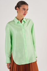 Profile view of model wearing the Oroton Silk Long Sleeve Shirt in Pear and 100% Silk for Women