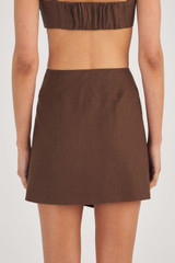 Profile view of model wearing the Oroton Scallop Wrap Skirt in Dark Chocolate and 100% Linen for Women